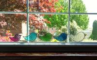 Stained glass standing birds that comes in three sizes of baby, child, parent, and in twelve birthstone colors of cathedral art glass.