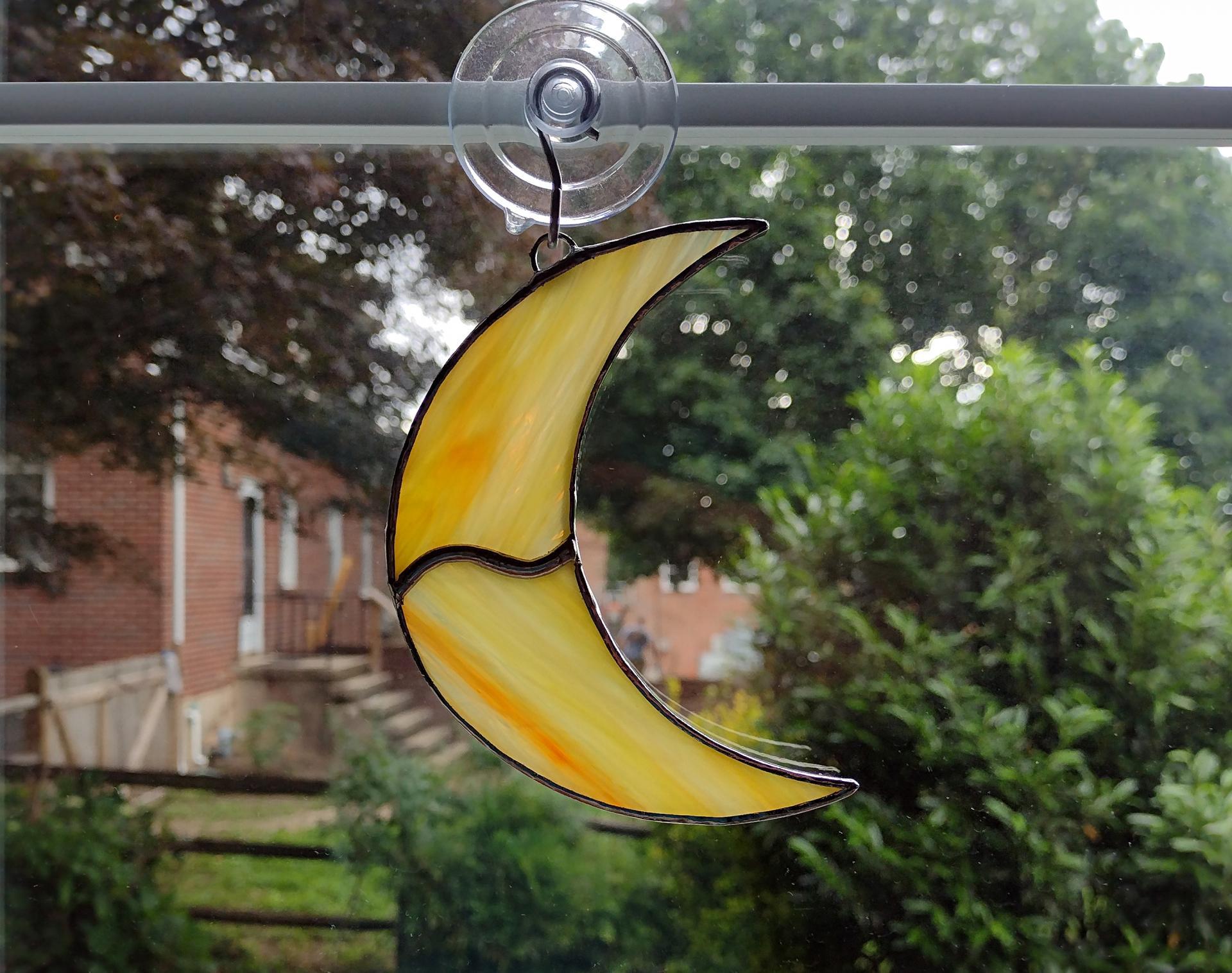 Stained glass crescent moon suncatcher, measures 4 1/2 in tall by 3 in wide.Made with orange and yellow swirled Corsica glass