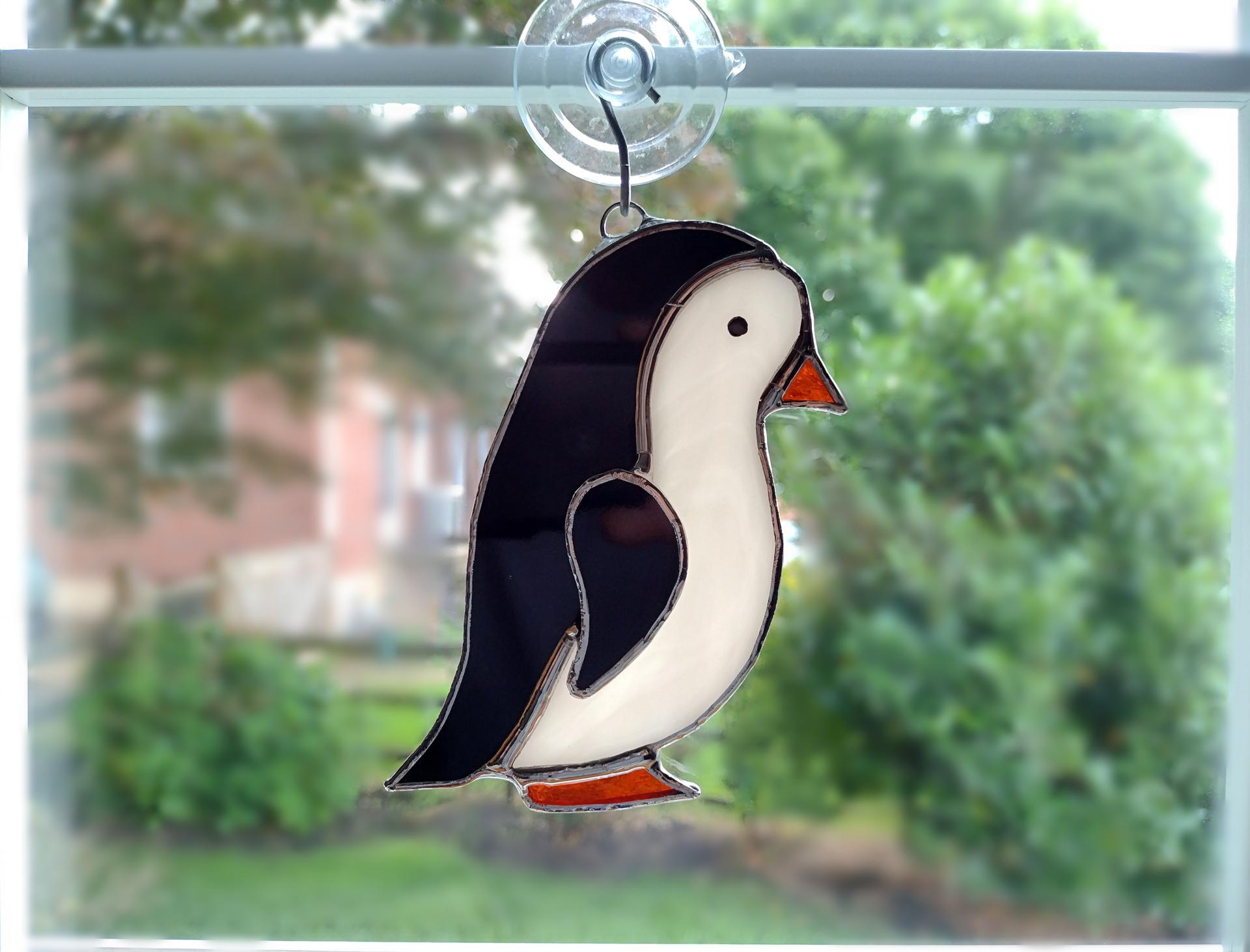 stained glass penguin available with a boy face or girl face, measures five inches by four inches and comes with a suction cup hanger.
