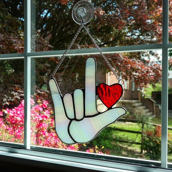 Stained Glass I Love you American sign language suncatcher with red heart, made with white iridescent art glass for the hand and red cathedral glass for the heart. Measure six inches by six and half inches, suction cup holder included.