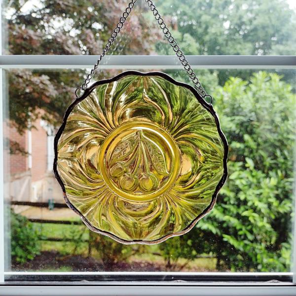 Six inch diameter vintage amber glass plate window hanging with a cherry motif. Comes with a chain and suction cup hanger.