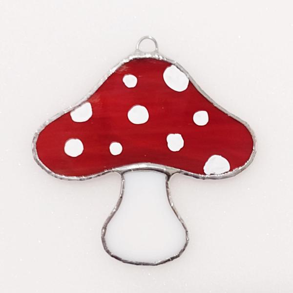 Red stained glass mushroom suncatcher with white spots and white stem.  Suction cup hanger included.