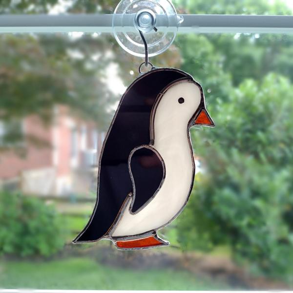 stained glass penguin available with a boy face or girl face, measures five inches by four inches and comes with a suction cup hanger.